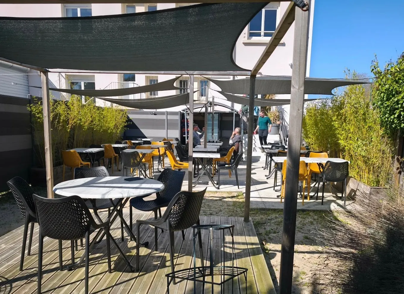 La terrasse extérieure ombragée par des voiles.